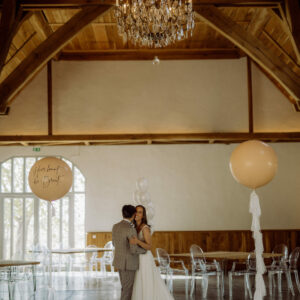 Brautpaar im Gartensaal unter dem Kronleuchter, links und rechts Ballons