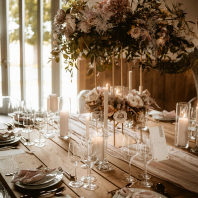 Eingedeckter Hochzeitstisch mit Blumenschmuck vor dem Gartensaalfenster