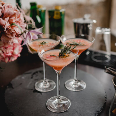 Drei gefüllte Cocktailgläser auf einer Cocktailbar im Torbogen