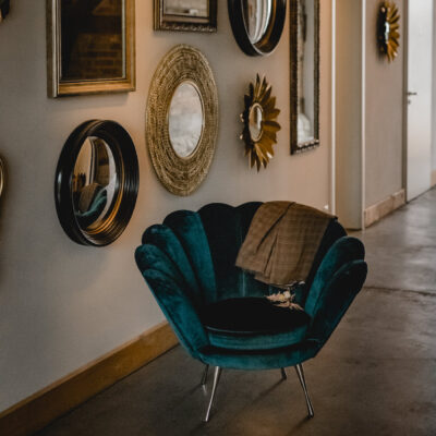 Türkisfarbener Sessel mit Jacket vor Spiegelwand im Gartensaal