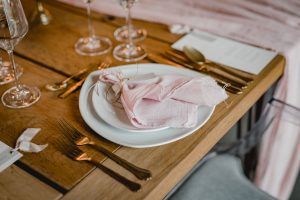 Gedeckter Tisch mit Geschirr und Besteck für eine Hochzeitsfeier