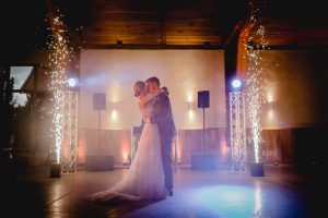 Brautpaar tanzt von Scheinwerfern beleuchtet im Gartensaal