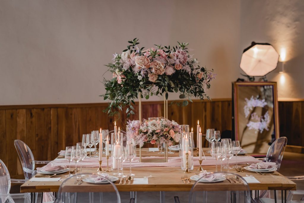 Gedeckter Tisch für eine Hochzeit im Gartensaal mit Blumenschmuck