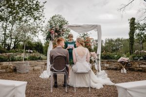 Brautpaar mit Traurednerin im Rondellgarten vom Gartensaal bei einer Trauzeremonie