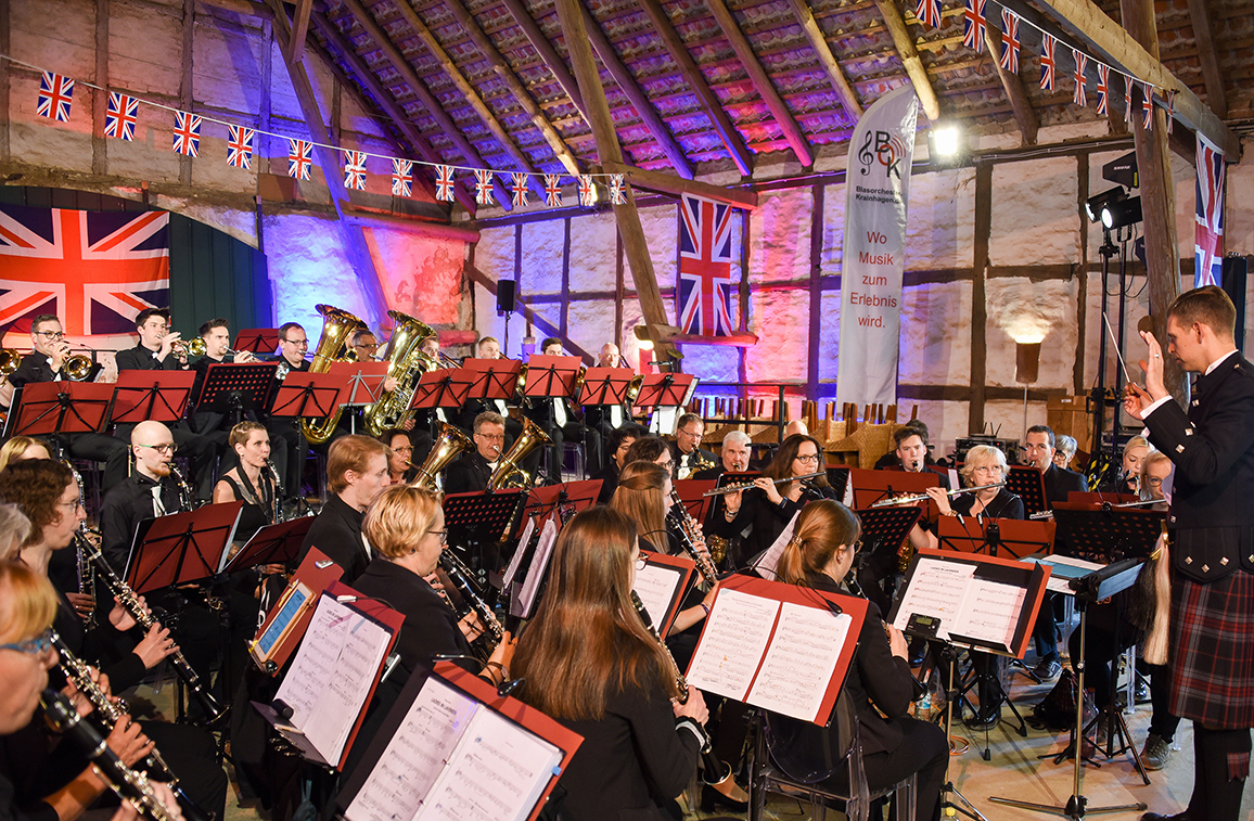 Mitglieder des Blasorchester Krainhagen musizieren in der großen, mit britischen Flaggen geschmückten Hofscheune, die während des British Weekend auf dem Rittergut Remeringhausen zur Konzertscheune wird.