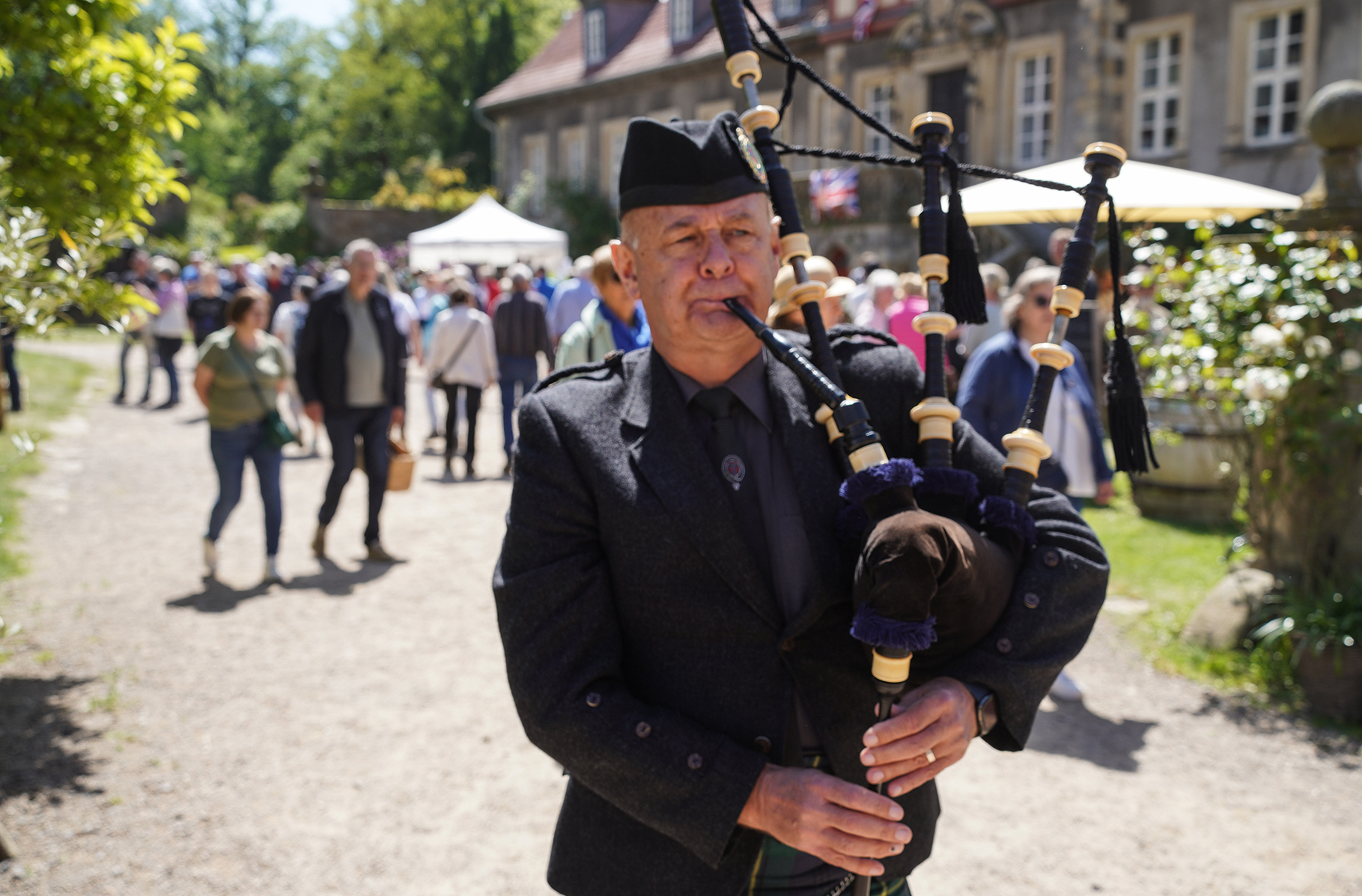 Piper David Johnston marschiert mit seinem Dudelsack vor dem Herrenhaus von Rittergut Remeringhausen auf und ab und unterhält die Besucher des Events British Weekend.