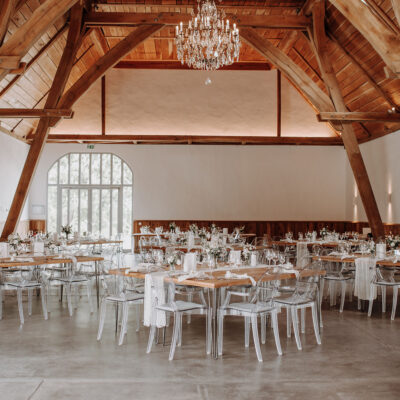 Großer Raum vom Gartensaal mit eingedeckten Tischen, geschmückt, oben von der Decke hängt der Kronleuchter