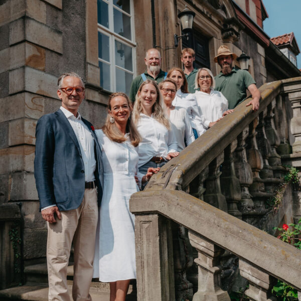 Team Remeringhausen mit Ehepaar v. Schöning steht auf der Treppe zum Herrenhaus.